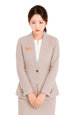 手を前で組み、不安そうな表情でたたずむ女性スタッフ